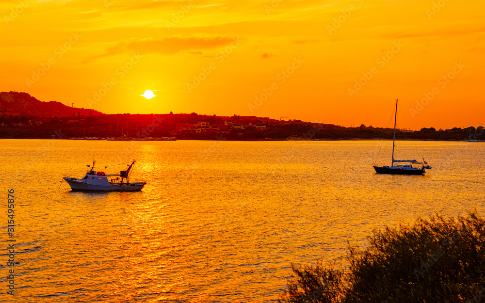 Sunrise or sunset with yachts at Porto Rotondo on Costa Smeralda at Mediterranean sea in Sardinia island of Italy. Boat in Sardegna in summer. Landscape of Olbia province. Mixed media.