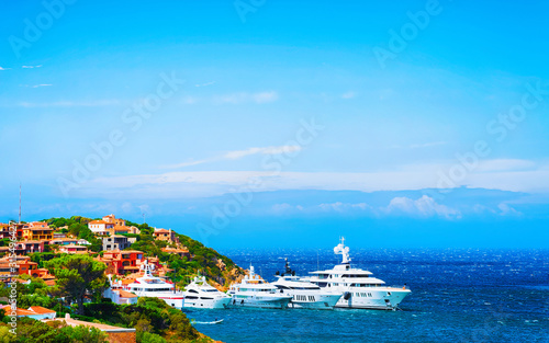 Scenery with Marina and luxury yachts at Mediterranean Sea of Porto Cervo in Sardinia Island of Italy in summer. Landscape View on Sardinian town port with ships and boats in Sardegna. Mixed media.