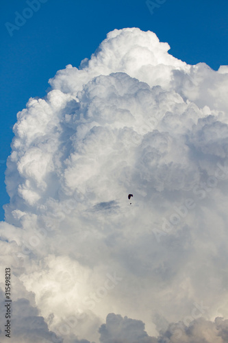 white active and powerful cumulonimbus cloud and deep blue sky, vertical mushroom cloud.paragliding