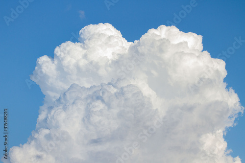 white cumulonimbus calvus cloud in deep blue sky,cumulo detail.vertical mushroom cloud photo