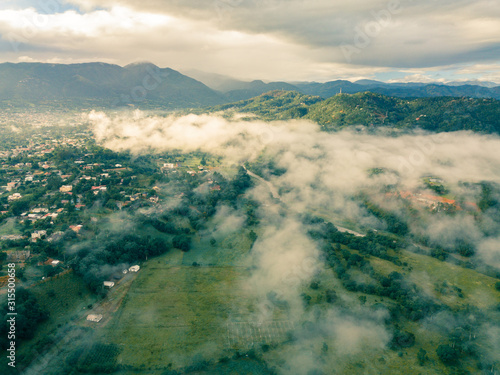 aerial landscape  fog and mist .cloudy morning in jarabacoa,dominican republic.el mogote mountain ,small village and in background photo