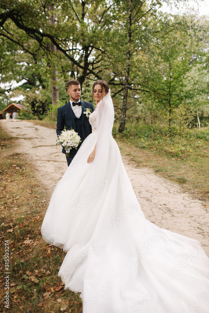 Newlyweds walking in forest. Happy just married couple Newlyweds walking in forest. Happy just married couple