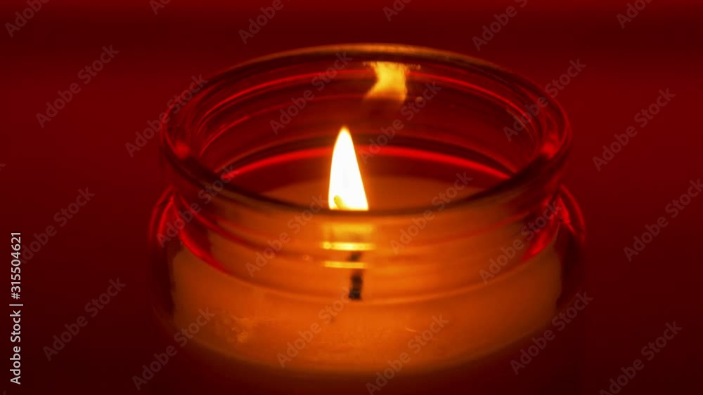Aroma candle stable flame in glass jar on red background Aroma candle stable flame in glass jar on red background