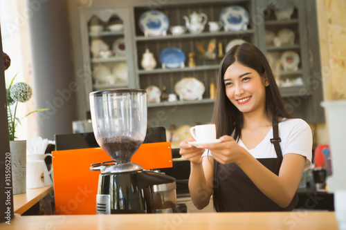 Happy woman working in a coffee shop.