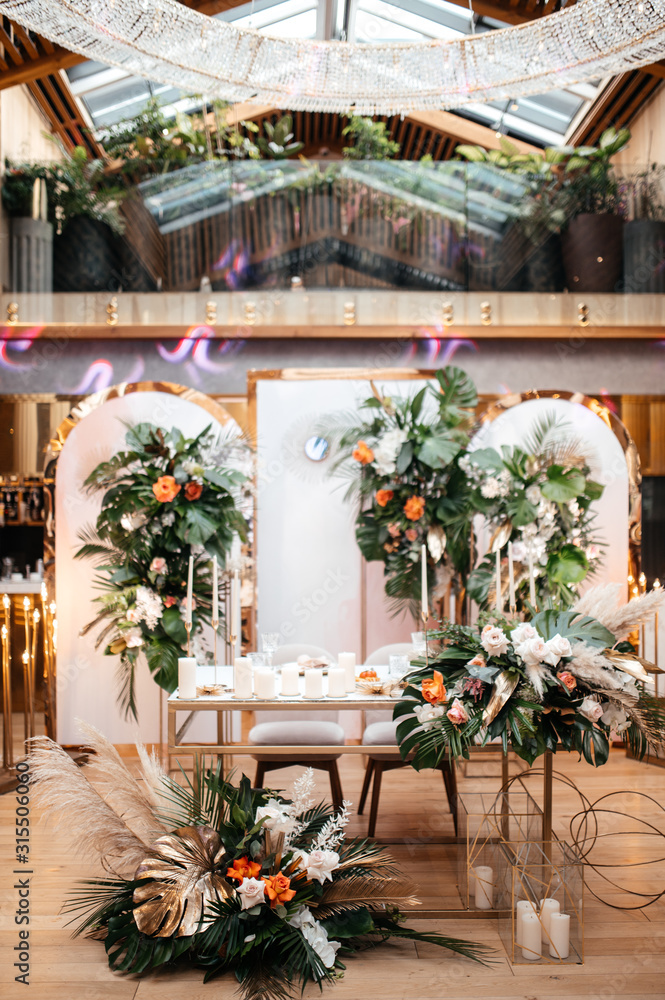 Wedding table serving. Wedding luxury decor. Wedding presidium for the newlyweds. Beautiful decor with pastel roses, candles and greenery. Indoors