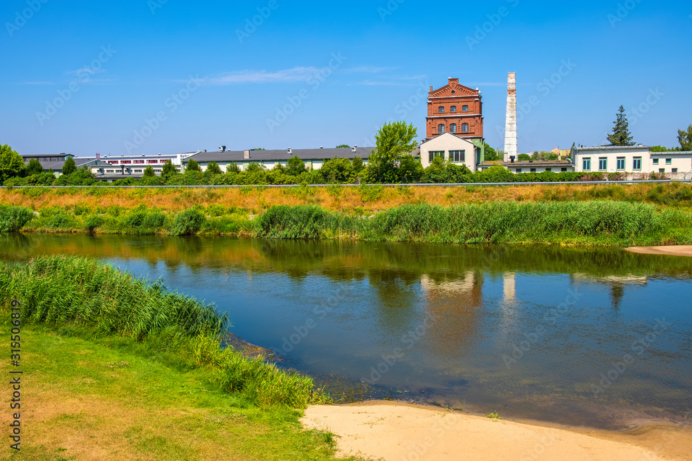 Historic industrial buildings over the Warta river, at the Nadbrzezna street in the historic quarter of Konin, Poland