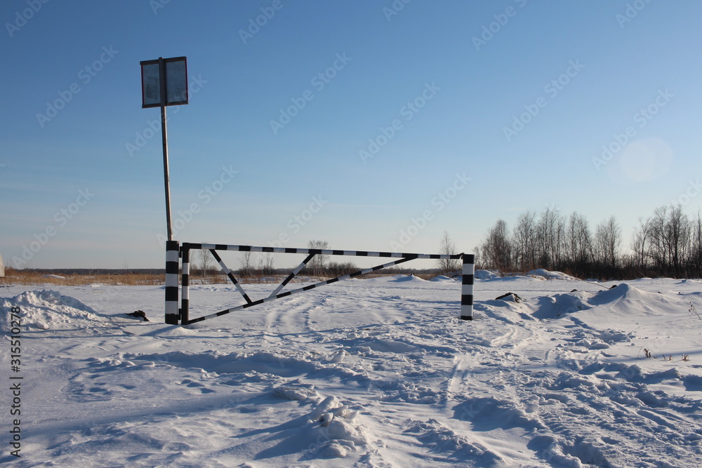 closed barrier in the snow prohibits entry to private territory