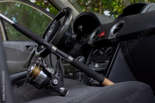Fishing rod with reel inside the car. Fishing travel concept.