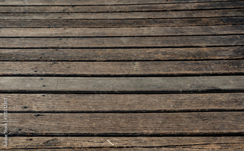 Worn wood deck at the marina, dark brown. Horizontal wood lines for background. Abstract. wood grain