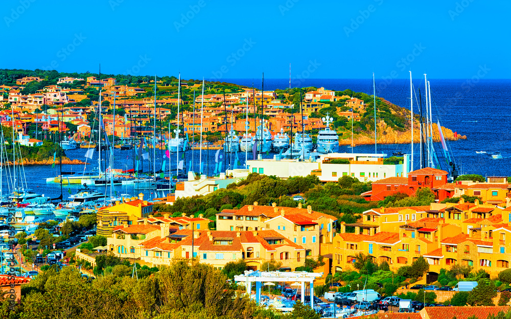 Obraz premium Scenery with Marina and luxury yachts at Mediterranean Sea of Porto Cervo in Sardinia Island of Italy in summer. Landscape View on Sardinian town port with ships and boats in Sardegna. Mixed media.