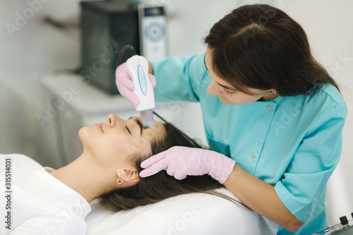 Female at cosmetic beauty spa clinic has facial hardware cosmetology. Woman making beauty procedures