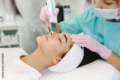 Young woman taking beauty procedure in spa salon