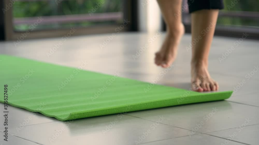 Close-up shot of woman relaxing on a yoga mat in a yoga studio with a view to the tropical jungle. Close-up shot of woman relaxing on a yoga mat in a yoga studio with a view to the tropical jungle.