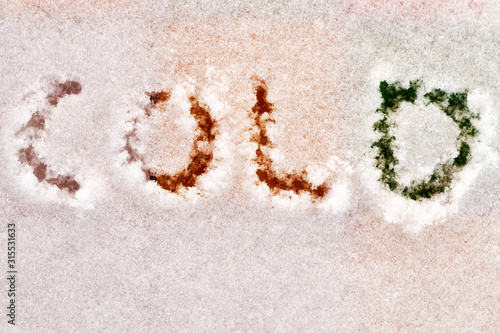 Cold word written on the frozen colorful table. Concept of winter, ice, and low temperature. Detailed white snowflakes pattern
