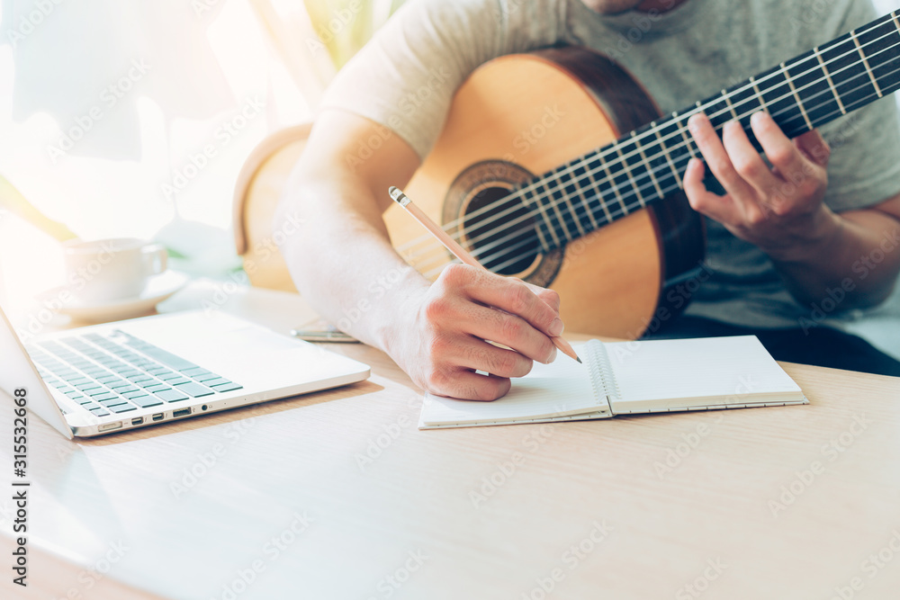 Fototapeta premium artist songwriter thinking writing notes,lyrics in book at studio.man playing live acoustic guitar relax chill.concept for musician creative.composer work process.people relaxing time with instrument