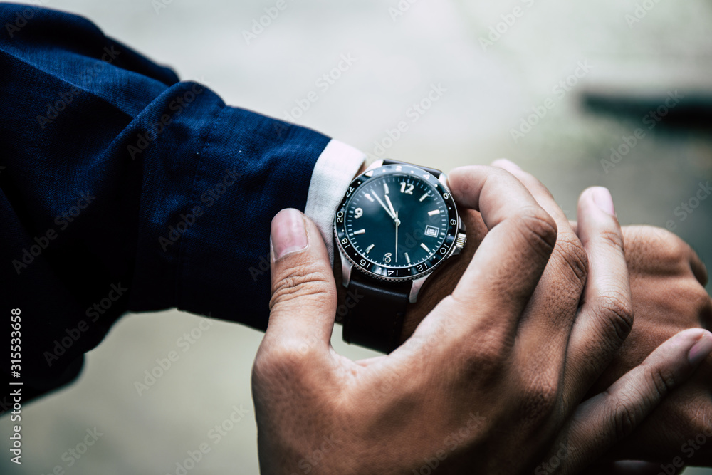 looking at luxury watch on hand check the time at workplace.concept for managing time organization working,punctuality,appointment.fashionable wearing stylish looking at luxury watch on hand check the time at workplace.concept for managing time organization working,punctuality,appointment.fashionable wearing stylish