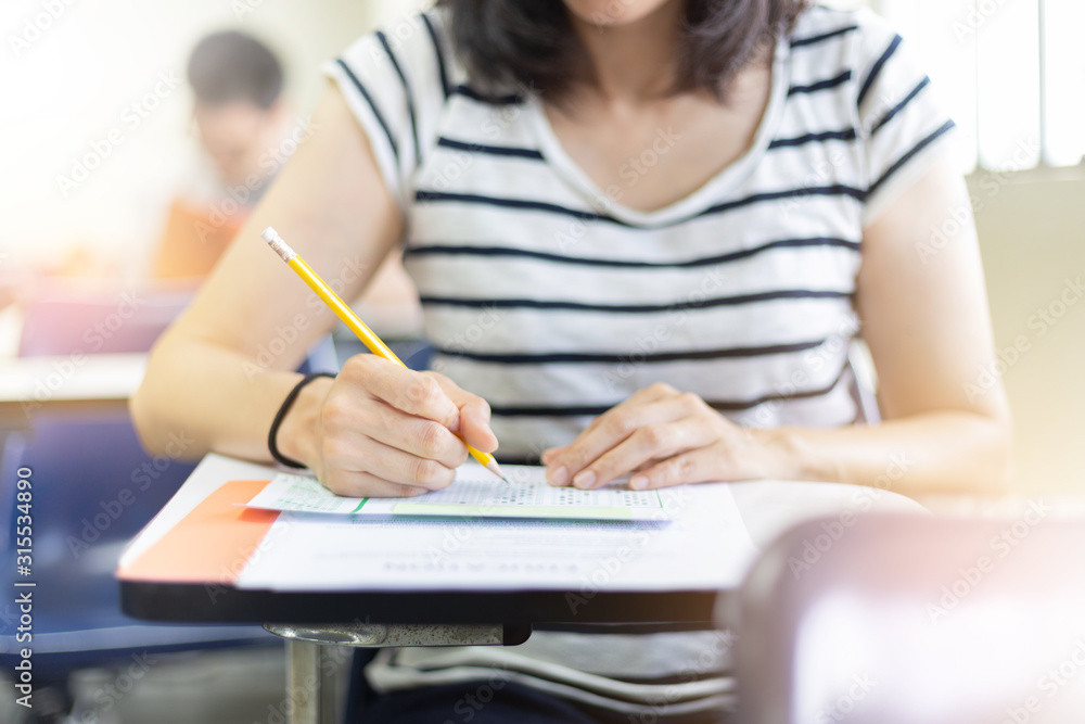 high school,university student study.hands holding pencil writing paper answer sheet.sitting lecture chair taking final exam attending in examination classroom.concept scholarship for education abroad high school,university student study.hands holding pencil writing paper answer sheet.sitting lecture chair taking final exam attending in examination classroom.concept scholarship for education abroad