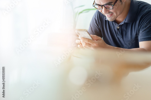 using cell phone.hand holding texting message on screen mobile chatting friend ,search internet information sitting on sofa in office.technology device contact communication connecting people concept