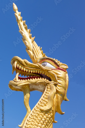 Golden dragon s head at the temple with blue sky background.
