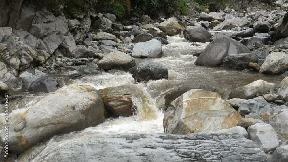 Water pouring over huge boulders in a washed out river bed on the Amazonian slopes of the Andes near the town of Banos, Tungurahua province, Ecuador. Water pouring over huge boulders in a washed out river bed on the Amazonian slopes of the Andes near the town of Banos, Tungurahua province, Ecuador.