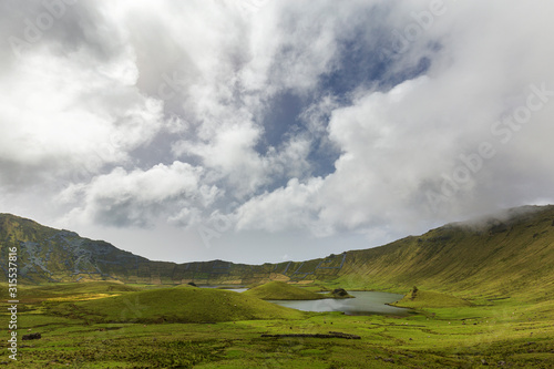 Blue sky peaks through the clouds on the valley floor in the Corvo Crater on the island of Corvo in the Azores, Portugal.