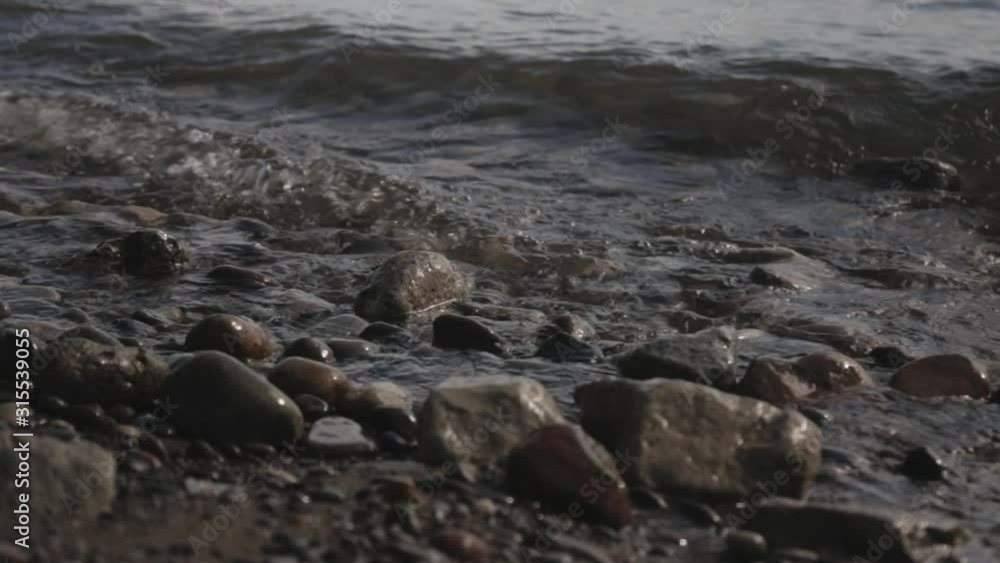 Close Up Of A Water Waves Splashing To The Rocky Shore During Sunny Day - Close Up Shot Close Up Of A Water Waves Splashing To The Rocky Shore During Sunny Day - Close Up Shot