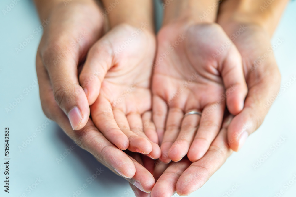 Close up of loving mom holding hands of kid concept care Close up of loving mom holding hands of kid concept care