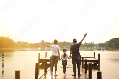 happy asian family at lake in the evening in thailand
