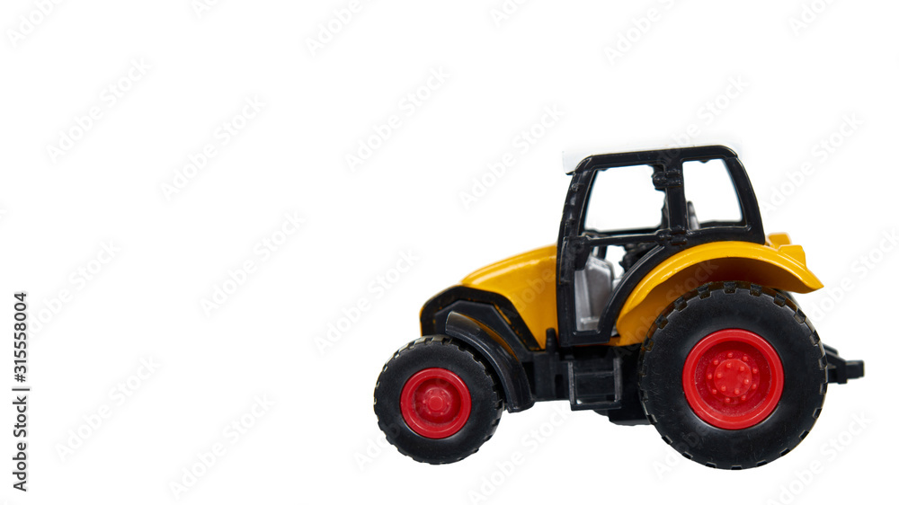 Yellow plastic traktor toy. Farming vehicle, harvest equipment.