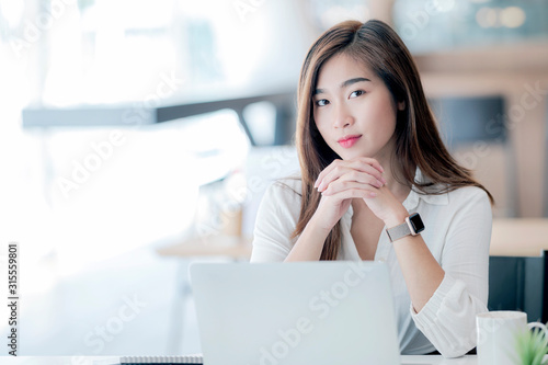 Portrait of  young businesswoman sitting at office desk. © NAMPIX