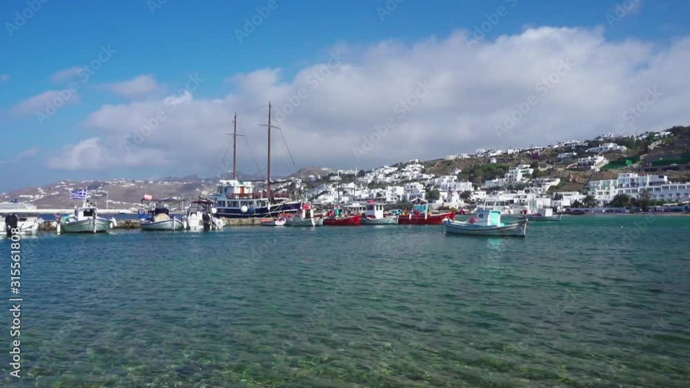 Panning shot of boats moored in the old port on the island of Mykonos, Greece. Panning shot of the seascape with calm seas, and typical white washed houses. Panning shot of boats moored in the old port on the island of Mykonos, Greece. Panning shot of the seascape with calm seas, and typical white washed houses.