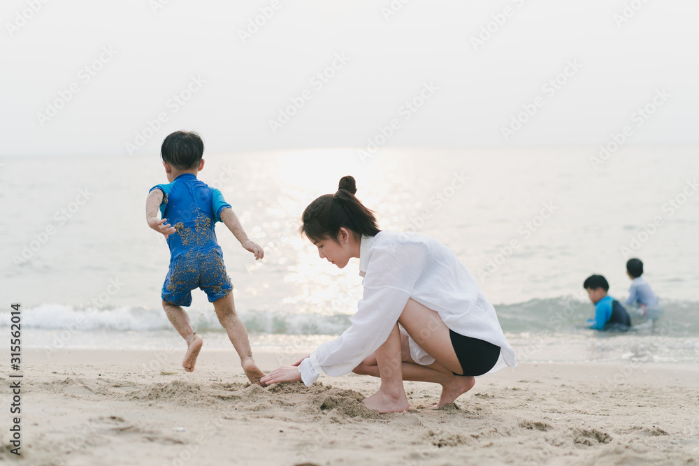 A mother is playing sand and swimming with her son on the beach. A mother is playing sand and swimming with her son on the beach.