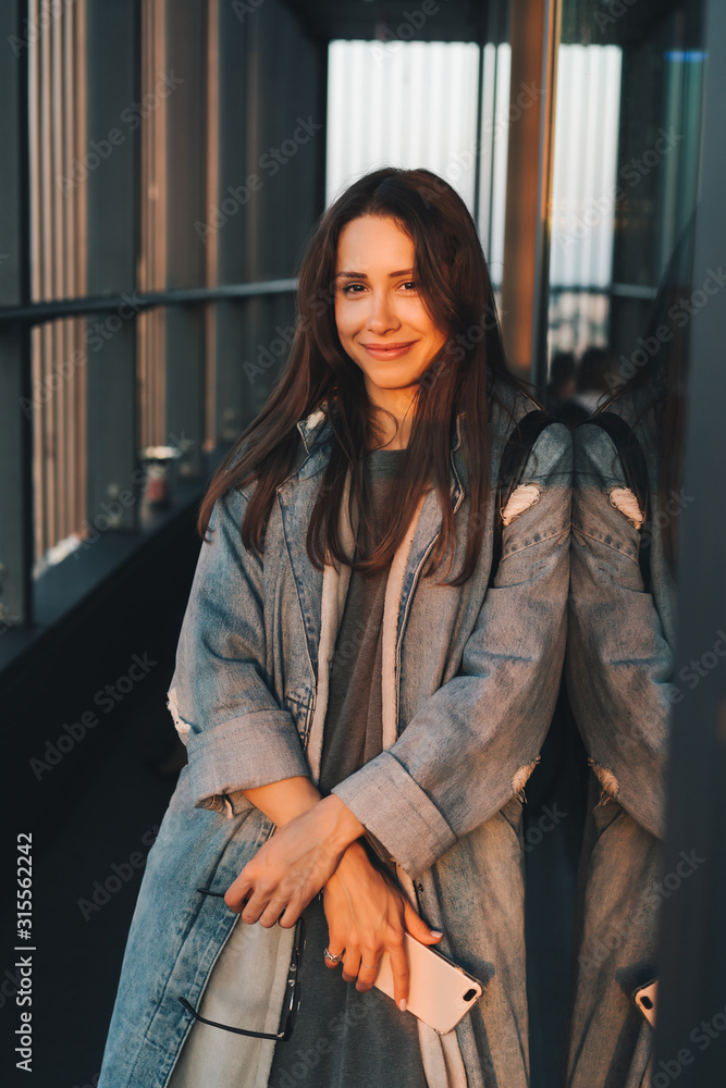 Portrait of a young attractive emotional girl dressed in a trendy blue denim coat Portrait of a young attractive emotional girl dressed in a trendy blue denim coat