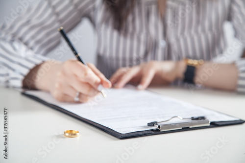 Young woman signing decree of divorce. © andranik123