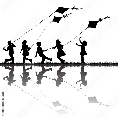 Children silhouettes playing with kites flying outdoor