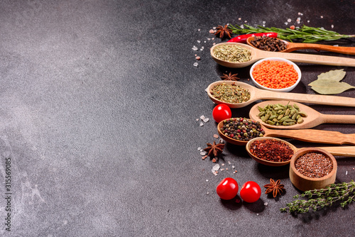 A set of spices and herbs. Indian cuisine. Pepper  salt  paprika  basil and other on a dark background