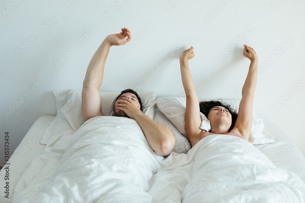 couple sleeping in bed with white sheets couple sleeping in bed with white sheets