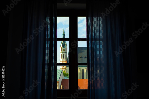 Facade of St. Vitus Church through a defocused window from inside of a house in Cesky Krumlov, Czech Republic