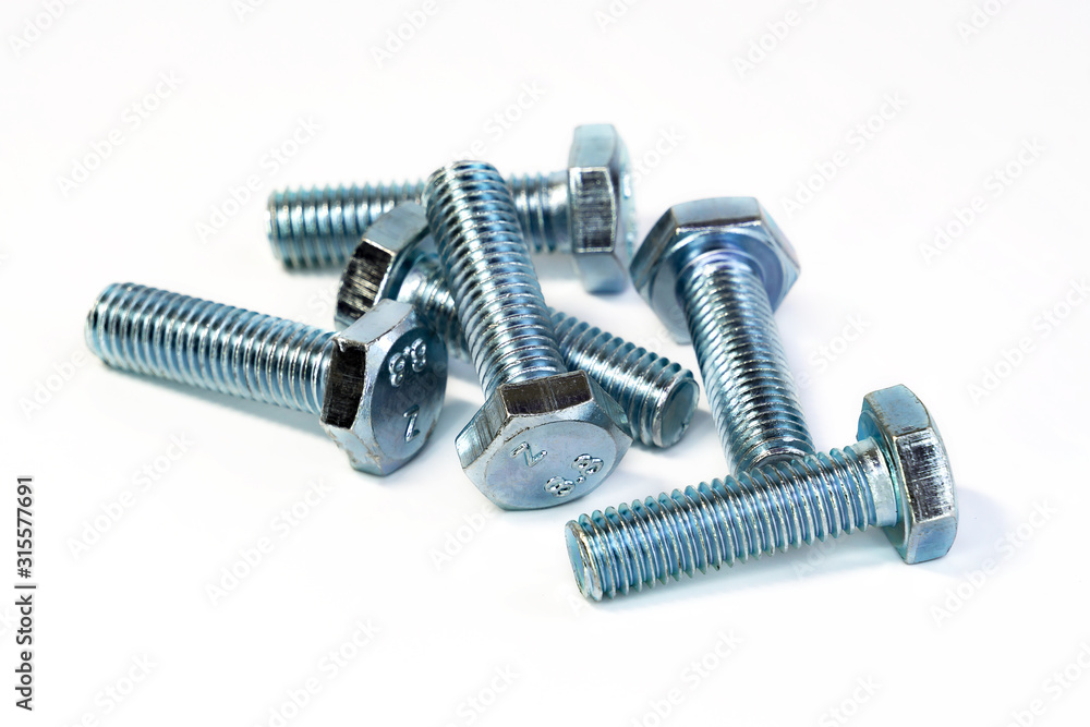 Metal chrome bolts with thread macro photography on an isolated background. The tools for the job. Selective focus. Metal chrome bolts with thread macro photography on an isolated background. The tools for the job. Selective focus.