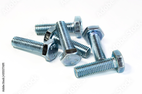 Metal chrome bolts with thread macro photography on an isolated background. The tools for the job. Selective focus.