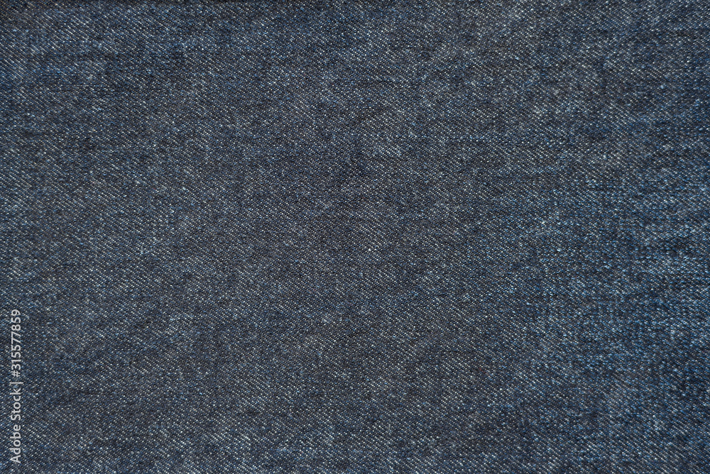 Dark blue denim background. Closeup of jeans texture and pattern. Classic blue color