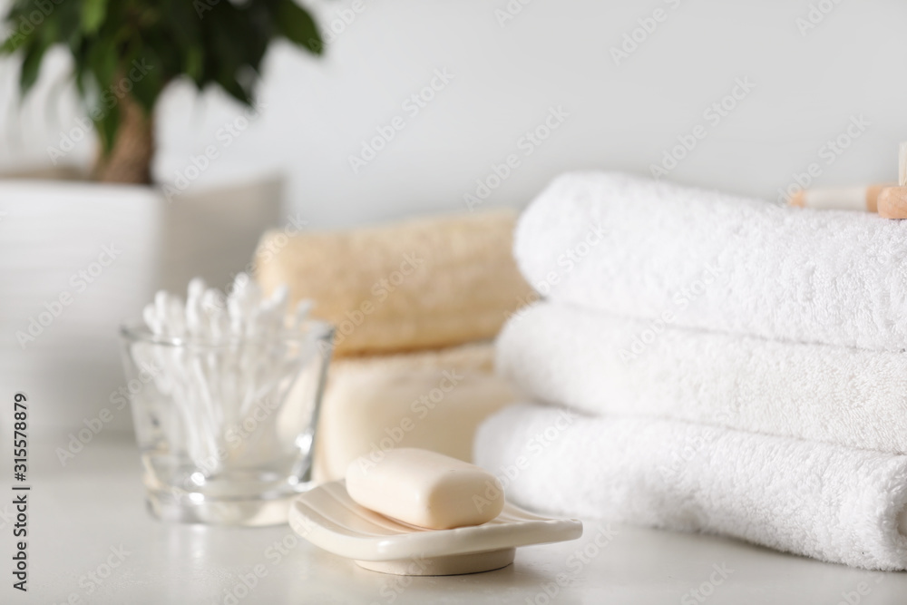 Soap bar and towels on white table indoors