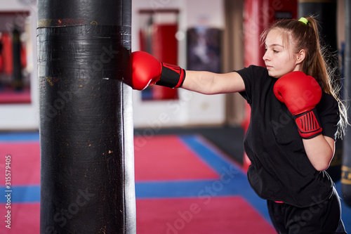 Boxer girl hitting the heavy bag