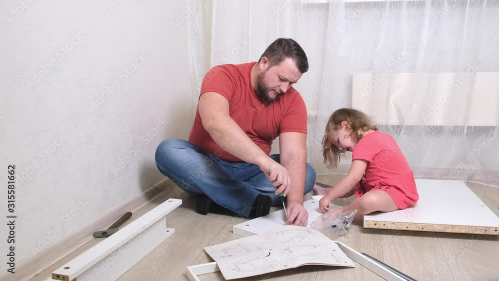 Dad man collects white home furniture. Daughter helps dad to collect furniture. Dad man collects white home furniture. Daughter helps dad to collect furniture.