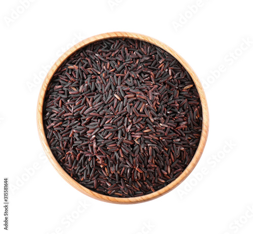Brown rice in wooden bowl isolated on white, top view