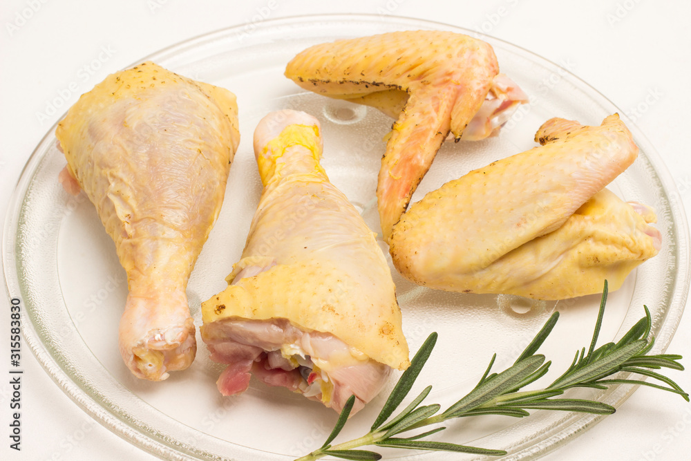Clean food concept. Parts of organic chicken (legs, wing) with yellowish skin grown by free range method outdoors.