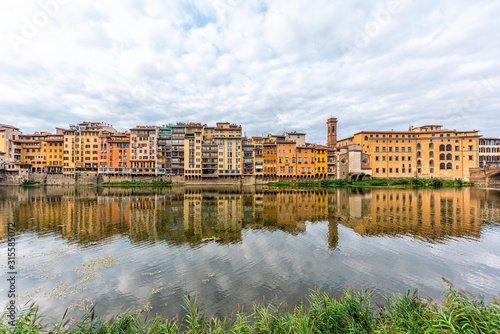 Florence, Italy Firenze orange yellow colorful buildings on Ponte Vecchio by Arno river during summer morning in Tuscany hdr reflection on water