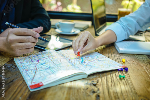 Business meeting. A man and a woman is talking about target area of customer in the map. They use pin point to locate the area target.