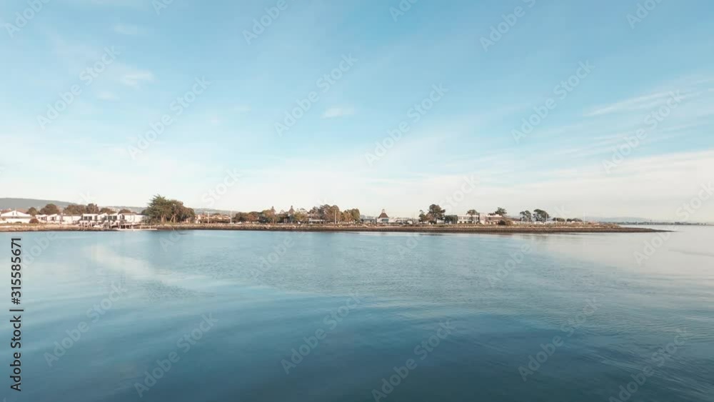 Calm silky waters under the blue skies over the bay near the beach. Calm silky waters under the blue skies over the bay near the beach.