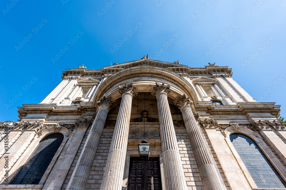 London, UK St Paul's Cathedral wide angle exterior architecture low angle view with blue sky and columns in center of downtown district city